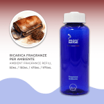 Flacone blu di ricarica per fragranza ambiente 'Cuoio e Tabacco' de I Profumatori, con indicazione dei formati disponibili. A sinistra, un'illustrazione circolare mostra una borsa o astuccio in pelle marrone scuro semiaperto con del tabacco da pipa sciolto accanto, che evocano il carattere maschile e misterioso della fragranza.