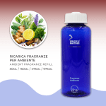 Flacone blu di ricarica per fragranza ambiente 'Apoteosi Aromatica' de I Profumatori. Sono indicati i formati di ricarica: 50ml, 150ml, 475ml, 975ml. A sinistra, un'illustrazione circolare mostra ingredienti aromatici e speziati: zenzero, mezzo limone, lavanda e una stecca di cannella.